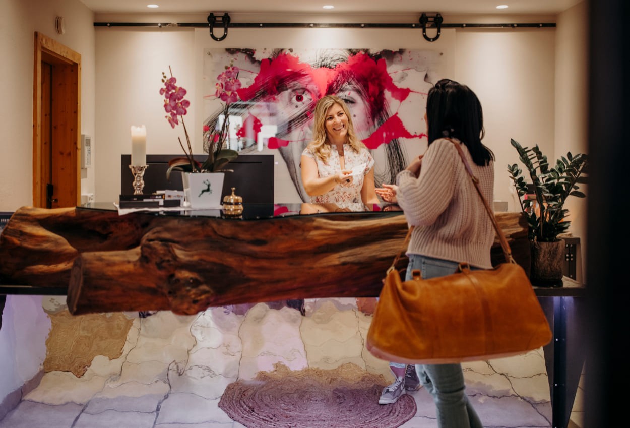 Nina begrüßt die Gäste an der Rezeption.