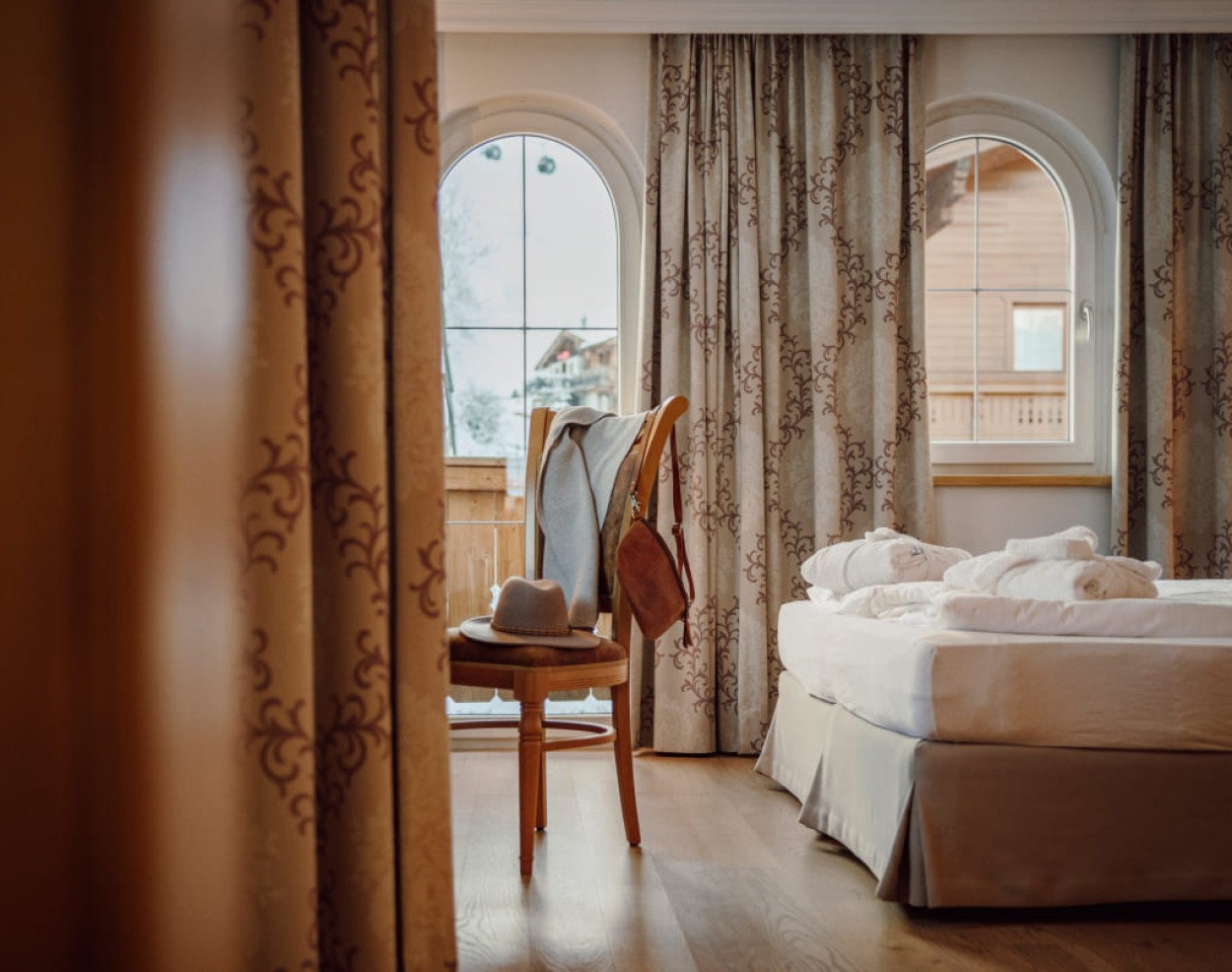 Turmzimmer: Bett mit Balkontür im Zimmer im 3-Sterne-Hotel im Salzburger Land