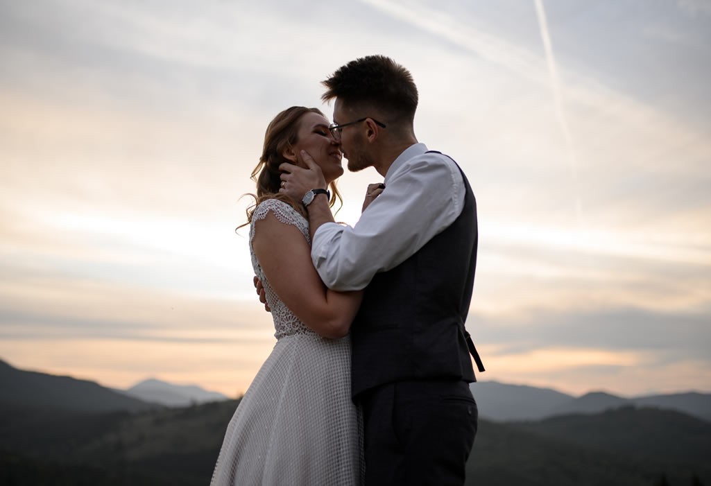 Hochzeitspaar küsst sich am Berg