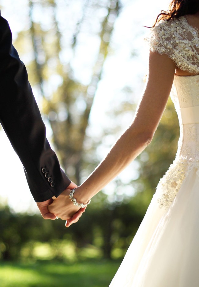 Brautpaar hält sich an den Händen