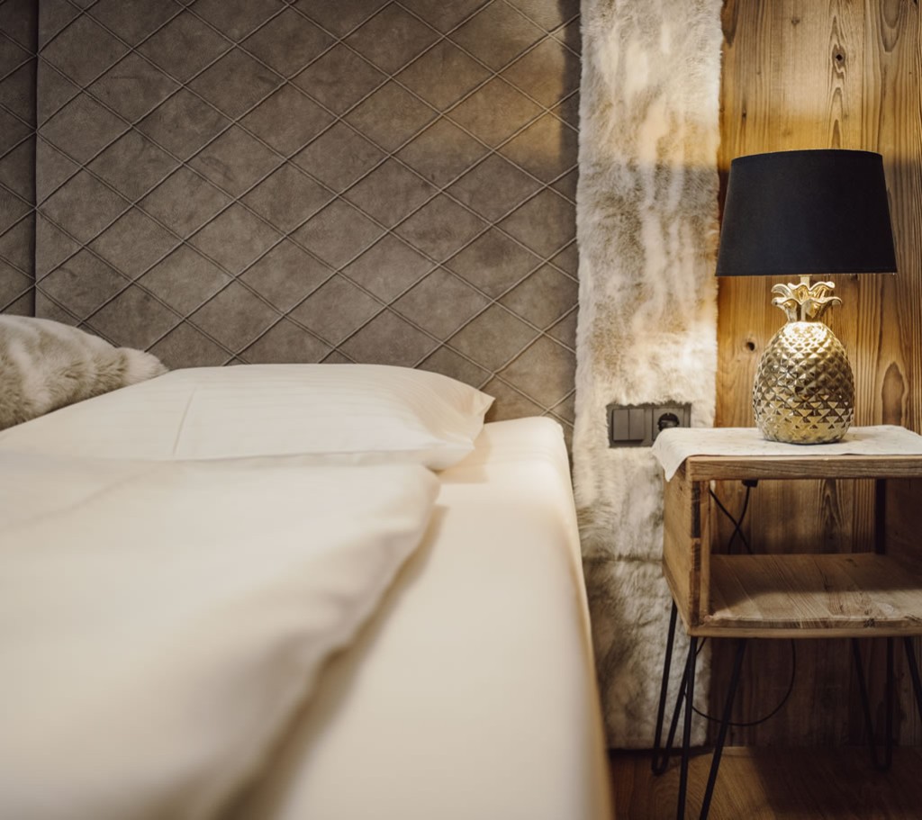 Gemütliches Bett mit modernen Deko-Elementen